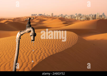 Tropfende Wasserhahn, Wüste und Skyline von Big City im Hintergrund, Konzept der globalen Erwärmung Planet, Wasserknappheit und der Fortschritte bei der Bekämpfung der Wüstenbildung Stockfoto