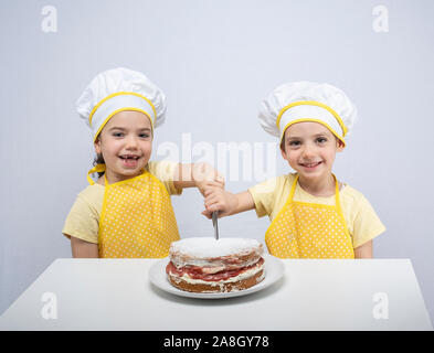 Junge Schwestern, Backen eines Kuchens zusammen im Studio Stockfoto