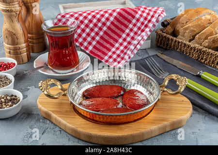 Türkisches Frühstück mit gebratenen türkischen sucuk (Bratwurst). Würstchen gebraten in Kupfer pan Stockfoto