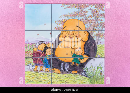 Rosa Wand von Tokyo Shushoin Tempel dekoriert mit hübschen Illustrationen auf Fliesen des buddhistischen Gottheit Hoteison Symbol der Großzügigkeit, die eine der Stockfoto