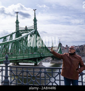 Budapest, Ungarn - 03 16 2019: Touristen machen eine selfie mit Smartphone auf der Freiheitsbrücke (szabadság Hid) in Budapest, Ungarn. Stockfoto