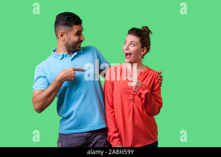 Portrait von überrascht junges Paar in Freizeitkleidung stehend mit geöffnetem Mund, umarmen, als Freunde, zeigen und sich einander schockiert. Stockfoto