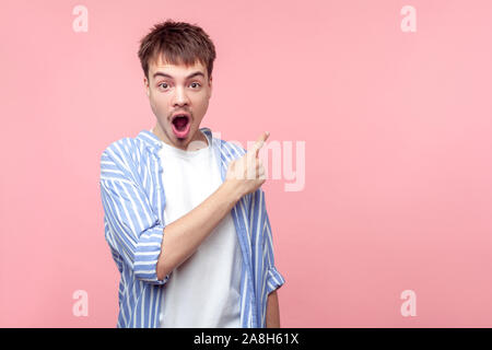 Wow Schockierende Neuigkeiten! Portrait von überrascht braunhaarige Mann mit dem kleinen Bart und Schnurrbart in casual Shirt zur Seite, der auf Kopie Raum für Informationen, Loo Stockfoto