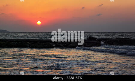 Rote Sonne in einem Abend über die ruhige See in der Nähe von Strand, himmel sonnenuntergang Farbe. Stockfoto