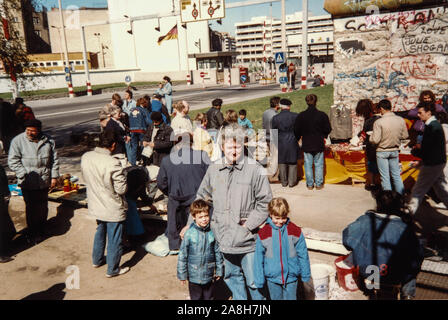 Michael Scott/Alamy Live Nachrichten - Berlin, Deutschland April 1990 - Urlaubsbilder auf einem Markt berücksichtigt neben einem Abschnitt der Berliner Mauer mit Souvenirs von Wänden, militärische Uniformen und Bilder in Deutschland im April 1990 nur wenige Monate nach der Mauer 1989 Stall. Stockfoto