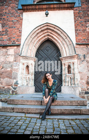 Schöne skinny albanische Mädchen posiert und zeigt die Orange Blue ornament Kleid Stockfoto