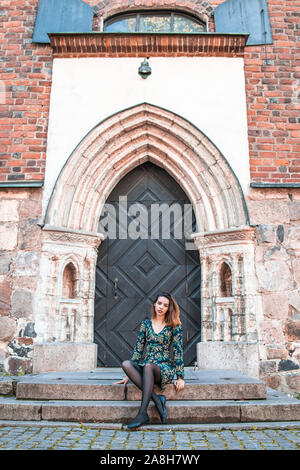 Schöne skinny albanische Mädchen posiert und zeigt die Orange Blue ornament Kleid Stockfoto