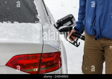 Man tanken zu seinen Diesel an der Tankstelle im Winter. Detail auf Schnee Tank und Pumpe Düse abgedeckt. Stockfoto