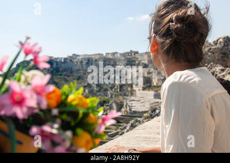 Junge elegante Frau Tourist in der historischen Stadt Matera in Italien sucht im Stadtbild Stockfoto