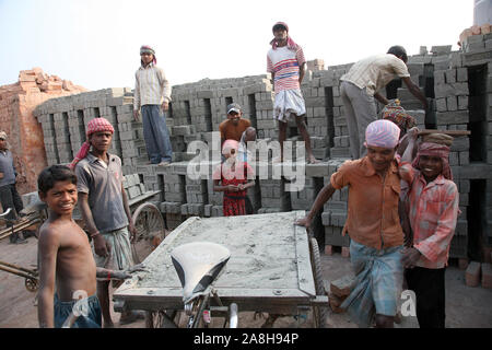 Brick Außendienstmitarbeiter, die komplette Oberfläche Backstein aus dem Brennofen, und laden Sie es auf ein Fahrrad Rikscha in Sarberia, West Bengal, Indien Stockfoto