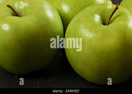 Grüne Äpfel auf dem Schwarzen Brett - closeup Foto mit Details zur Struktur der Haut. Stockfoto