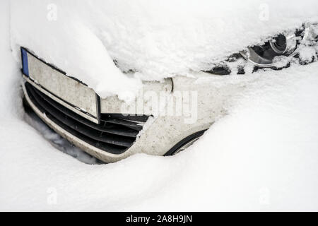 Auto unter tiefen Schicht Schnee nach schweren Schneesturm, Detail auf nur einen Teil der Scheinwerfer und vordere Stoßfänger sichtbar. Stockfoto