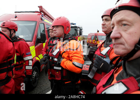 Feuerwehr und Rettungsdienste evakuieren ein behinderter Mann aus seinem Haus nach dem Hochwasser im Bentley Bereich von Doncaster nach einem Monate Niederschlag fielen auf einen Tag caausing den Don seine Banken zu verletzen. Stockfoto