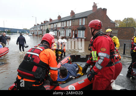 Feuerwehr und Rettungsdienste evakuieren ein behinderter Mann aus seinem Haus nach dem Hochwasser im Bentley Bereich von Doncaster nach einem Monate Niederschlag fielen auf einen Tag caausing den Don seine Banken zu verletzen. Stockfoto