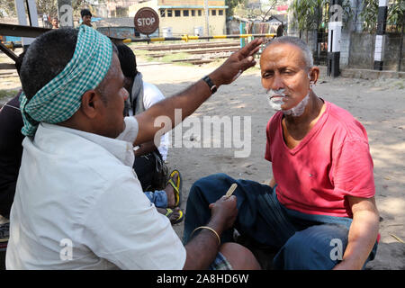 Straße Friseur rasieren ein Mann mit einem Rasiermesser auf einer Straße in Kolkata, West Bengal, Indien blade Stockfoto