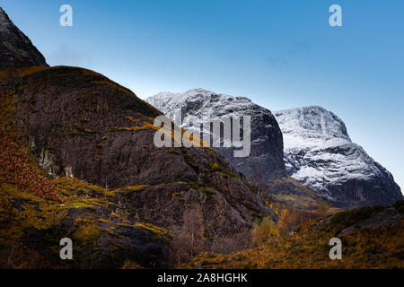 Saison ändern vom Herbst in den Winter in den schottischen Highlands. klare Himmel über schneebedeckte Berggipfel und Herbstfarben im Tal unten. Schöne Szene. Stockfoto