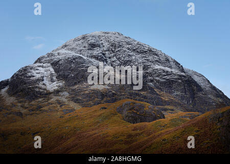 Blauer Himmel, schneebedeckte Gipfel im schottischen Hochland und Herbstfarben im Tal unten. majestätischen Landschaft von Glencoe, Schottland, UK. ersten Schnee. Stockfoto