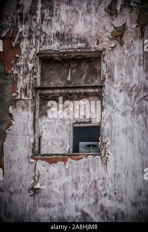 Eine zerstörte Fenster auf eine alte verlassene Gebäude Stockfoto