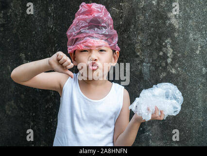 Süße kleine Mädchen posiert mit Plastiktüten. Konzept für die Anwendung von Plastikbeutel. Stockfoto