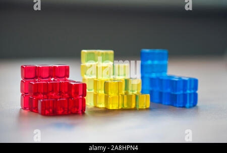 Gestapelte bunte Würfel. Vergleich, Illustration, Bausteine, Gelb, Blau, Rot. Stockfoto