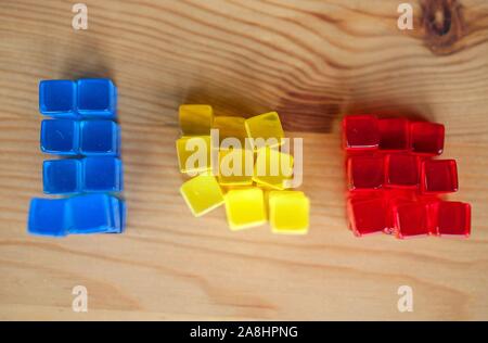 Gestapelte bunte Würfel. Vergleich, Illustration, Bausteine, Gelb, Blau, Rot. Stockfoto