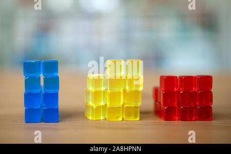 Gestapelte bunte Würfel. Vergleich, Illustration, Bausteine, Gelb, Blau, Rot. Stockfoto