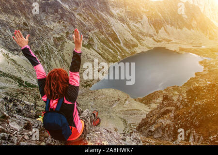 Mountain Lake malerische Landschaft. Hohe Felsen. Schöne Landschaft. Die Slowakei, Hohe Tatra. Happy Reisen Frau sitzt auf dem Gipfel. Stockfoto