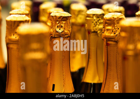 Champagner Flaschen in der Vinothek. perspektivische Ansicht Detail der goldenen Champagner flaschen Tops geordnet im Regal. Selektive konzentrieren. Stockfoto