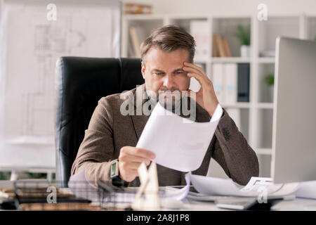 Nachdenklich Architekt auf Skizze auf Papier, während die Konzentration auf Arbeit Stockfoto