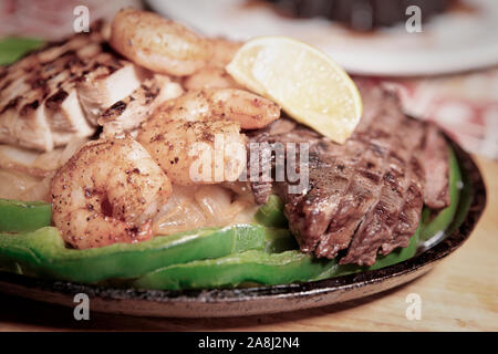 Fajitas in Metall pan auf Holzbrett, flacher Fokus Stockfoto