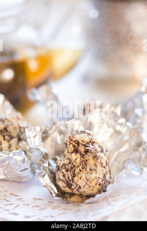 Bonbons in Schokolade und zerdrückten Wafer auf einem weißen Tisch Stockfoto