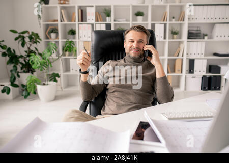 Fröhliche reife Architekt oder Geschäftsmann mit Smartphone im Gespräch mit Kunden Stockfoto
