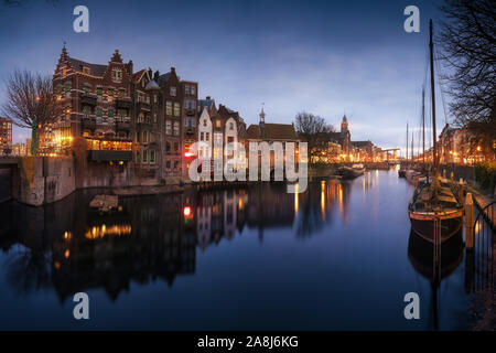 Delfshaven Harbour, Rotterdam, Niederlande. Winter Abend. Die Lichter der Stadt. Klaren spiegel Reflexionen. Boote verankert. Stockfoto