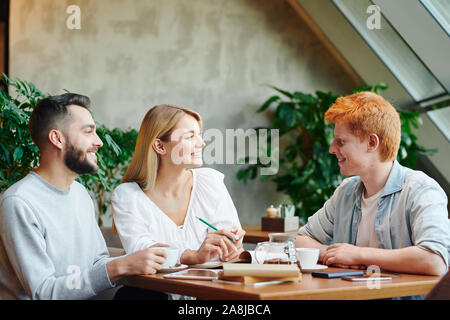 Gruppe der glückliche junge College Freunde von Tisch im Cafe versammelt nach Klassen Stockfoto