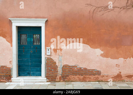 Vintage vordere Tür blau lackiert und eine Wand mit alten verwitterten Rendern in Venedig, Italien Stockfoto