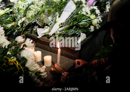 Ein Mädchen setzt oben Kerzen neben Blumen während der Rallye. Memorial Rally auf Tamar Park in Hongkong der Tod eines 22 Jahre alten Universität Student zu trauern, Alex Chow Tsz Lok, die von einer schweren Hirnverletzung bei einem Sturz am November gestorben 4. Als die Polizei skirmished mit Demonstranten am vergangenen Wochenende. Er war in kritischem Zustand verlassen und starb, nachdem er einen Herzstillstand. Stockfoto