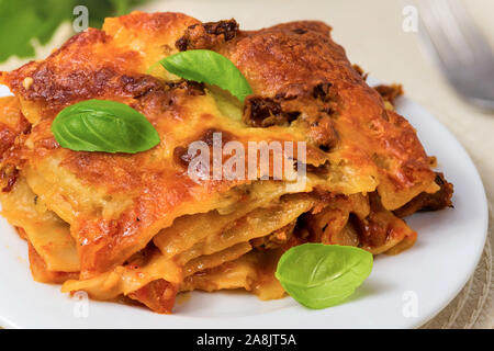 Lasagne mit Basilikum auf einem weißen Teller serviert Stockfoto