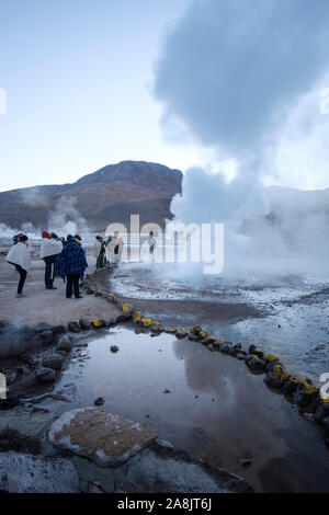 Touristen in der Nähe der Fumarolen bei El Tatio Geysir Feld im Norden Chiles Stockfoto