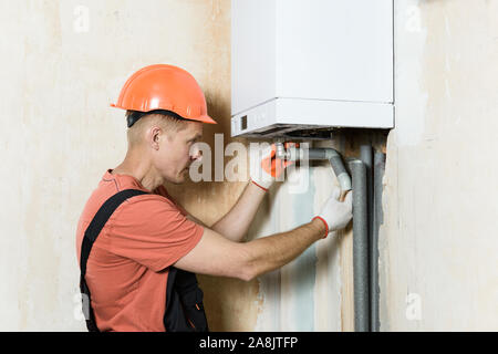 Der Arbeitnehmer ist die Verbindung der Rohre zu einem inländischen Gas Boiler. Stockfoto