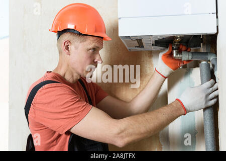 Der Arbeitnehmer ist die Verbindung der Rohre zu einem inländischen Gas Boiler. Stockfoto