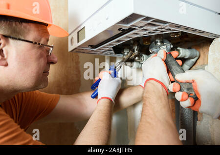 Der Arbeitnehmer ist die Verbindung der Rohre zu einem inländischen Gas Boiler. Stockfoto