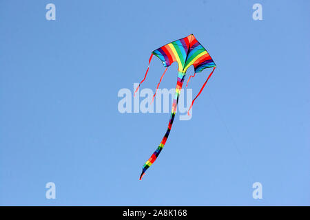 Bunter Drachen am blauen Himmel, Drachen steigen lassen, Familie, Spass, Aktivität, Stockfoto