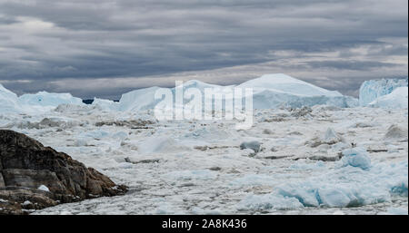 Eisberge schmelzen Gletscher im eisfjord - globale Erwärmung und den Klimawandel Eisfjord in Ilulissat, Grönland. Antenne drone Foto der arktischen Natur Eis Landschaft. Unesco-Weltkulturerbe. Stockfoto