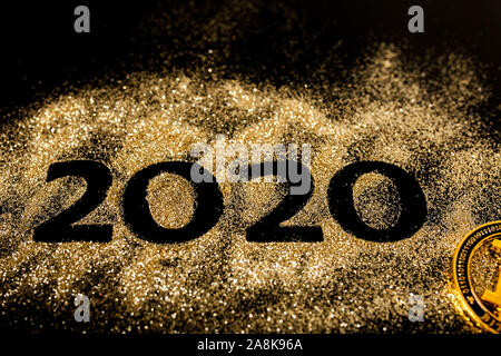 Frohes Neues Jahr 2020. Kreative Collage der Zahlen zwei und Null aus dem Jahr 2020. Schöne funkelnde Goldene Zahl 2020 und bitcoin auf Schwarz zurück Stockfoto