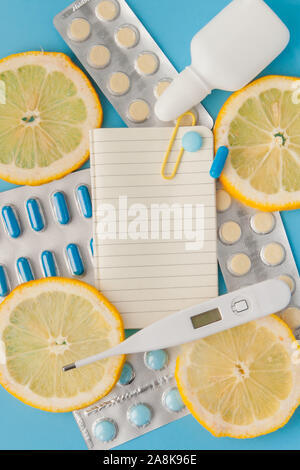 Medikamente, Pillen, Thermometer, traditionelle Medizin für die Behandlung von Erkältungen, Grippe, Wärme auf einem blauen Hintergrund. Aufrechterhaltung der Immunität. Saisonale Krankheiten. Stockfoto