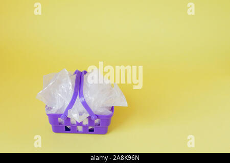 Polyäthylenbeutel im Warenkorb auf gelben Hintergrund. Stockfoto