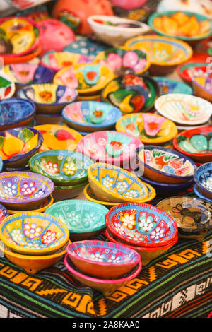 Ein Tisch voller handgemalter bemalter Schüsseln, die auf einem Markt im Freien auf einem Touristenmarkt in Mexiko zu verkaufen sind Stockfoto