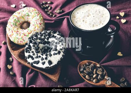 Elegante Konzept der Kaffee serviert. Kaffee mit bunten Croissants auf einem dunklen Hintergrund. Stockfoto