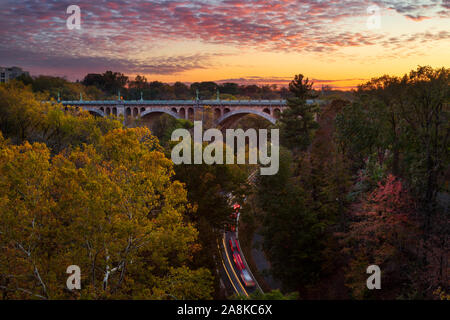 Blick auf den William Howard Taft Brücke und Autos in Rock Creek Park im Nordwesten von Washington, DC, bei Sonnenuntergang im Herbst Stockfoto