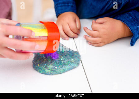 Der Schleim. Kinder spielen mit Blue Magic glitter Schleim auf einem weißen Hintergrund. Selektive konzentrieren. Stockfoto